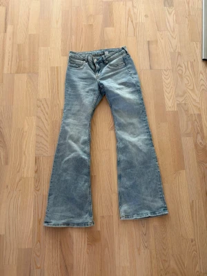 Ljusblå lågmidjade utsvängda jeans - Säljer ett par ljusblå jeans med utsvängda ben från H&M. Aldrig använd pga för små.