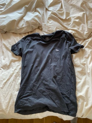 Svart t-shirt från Lee - En svart t-shirt från Lee i regular fit med liten logga på bröstet. Klassisk rund hals och korta ärmar. Tillverkad i mjuk bomull som känns skön mot huden. Perfekt basplagg till garderoben.