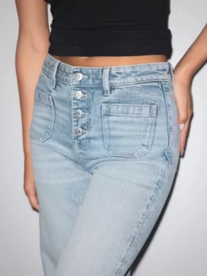 Ljusblå high waist jeans med raka ben - Säljer ett par ljusblå high waist jeans med raka ben och knappar framtill. Jeansen har stora fickor fram och är tillverkade i klassiskt denimtyg. Perfekta för en avslappnad och trendig look.