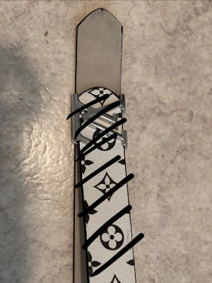 Vitt bälte med svart monogrammönster - Fråga för mer bilder 