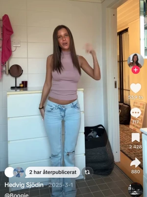 Ljuslila ärmlös polotopp - Säljer en ljuslila ärmlös polotopp med tight passform. Toppen har hög hals och är croppad, vilket ger en modern och trendig look. Perfekt att matcha med jeans eller kjol för en snygg outfit.