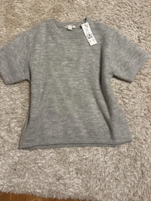  stickad t-shirt  - Grå stickad T-shirt ifrån Gina. HELT NY.   OBS! Strl 170 men passar allt från 170-S. Nypris 199 Hör av er om ni undrar över något!💕💖 Öppen för prisförslag!