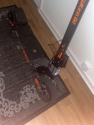 Svart och orange elscooter Kukirin G2  - Säljer en elscooter av modellen Kukirin G2 i svart med orange detaljer. Scootern har breda däck, robust ram i metall och laddas via medföljande laddare. Perfekt för dig som vill ta dig fram snabbt och smidigt i stan. LED-belysning fram för extra synlighet helt nya däck inget fel med den kom gärna kolla!