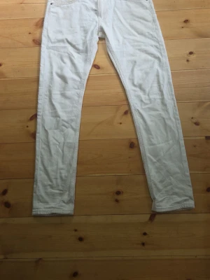 Vita slim fit Lee jeans - Snygga vita skinny jeans med klassisk femficksdesign och smal passform. Jeansen har normal midja och är tillverkade i ett stretchigt denimtyg som ger en bekväm känsla. Perfekta att matcha med en oversized hoodie eller crop top.
