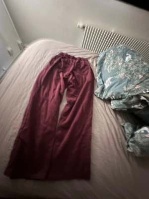Vinröda utsvängda leggings - Säljer ett par vinröda leggings med utsvängda ben och resår i midjan. Mjukt och stretchigt material som sitter skönt på kroppen. Perfekta för dig som gillar en avslappnad men trendig stil.