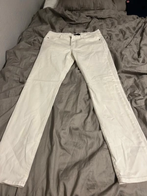 Vita Lindeberg jeans - Säljer ett par vita jeans med rak passform och klassisk femficksdesign. Jeansen har bälteshällor och dragkedjegylf. Perfekta för dig som vill ha en clean och stilren look. Materialet är bomull eller bomullsblandning. Pris kan diskuteras