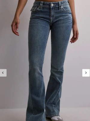 True Religion jeans med vingar i bak - Blåa True Religion bootcut jeans med vita broderade ving detaljer i bak. Jeansen är låg midjade och har femficksmodell. Aldrig använda med lappen kvar 💕Pris kan diskuteras! 