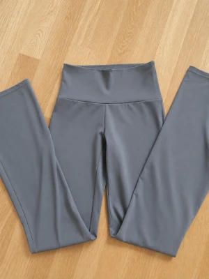 Gröna bootcut leggings med hög midja - Säljer dessa gröna tränings byxorna, de är bootcut/utsvängda med hög midja, men som även går att vika ner om man vill ha en mer lowwaist look. Använt ett fåtal gånger men ser helt nya ut. Fråga gärna om fler bilder elr om några mått..