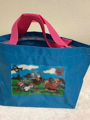 Barn Väskor med 3D djurmotiv - Säljer två shoppingväskor i slitstark plast, en blå och en mörkblå, båda med rosa handtag. Väskorna har söta tecknade djurmotiv på framsidan, bland annat kor och hästar. Perfekta för att bära böcker, mat eller annat smått och gott. 65kr/st 