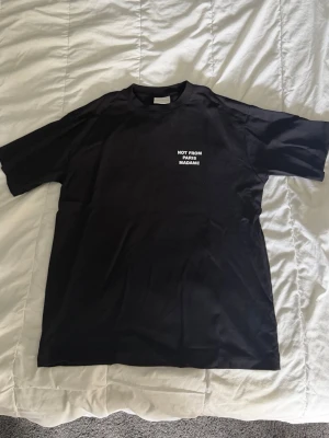 ”NOT FROM PARIS MADAME” Tshirt herr - Säljer denna svarta ”NOT FROM PARIS MADAME” Tshirt, köpt nydligen för 1299 från Care of Carl och knappast använd! Kom med förslag på pris som är rimliga! Inga defekter eller likande som bör kännas till! Storlek medium med avslappnad passform! Kvitto finns privat! 