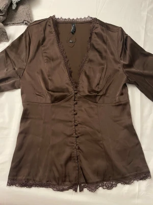 Dressed up lace shirt in Small - Tröja från newyorker. Brown lace dress up shirt , Full sleeved, worn once , tag is still with, cutouts at the hands. Selling because its not getting used. 
