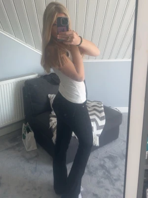 True religion jeans - Säljer ett par svarta bootcut jeans med snygga fickdetaljer bak och knappstängning. Jeansen har en klassisk passform med utsvängda ben och sitter tajt över höfterna. Perfekta för dig som vill ha en trendig och bekväm look.