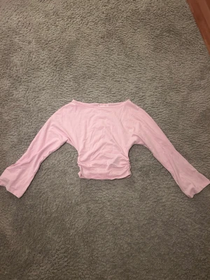 Ljusrosa topp från Gina Tricot - Supersöt ljusrosa topp från Gina Tricot med rynkade detaljer vid midjan. Perfekt för dig som gillar en feminin och enkel stil. Mjuk och skön känsla, passar till många olika outfits.Storlek 134/140