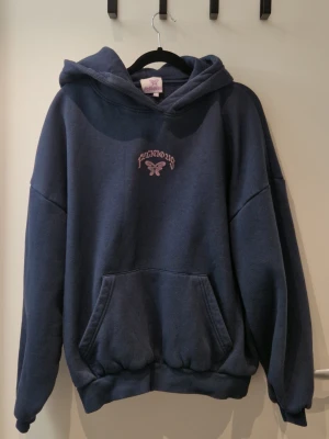 Felicious Hoodie Marinblå - Använd men i bra skick. Trycket har blivit urtvättat se bilder.