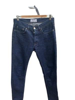 Mörkblå  jeans - Acne Studios - Snygga mörkblå skinny jeans från Acne Studios med klassisk femficksmodell och hög midja. Jeansen har en smal passform och är tillverkade i stretchigt denimtyg för extra komfort. Perfekta till alla dina favoritoutfits! I storleksskalan XS-XL sitter denna som S/M.