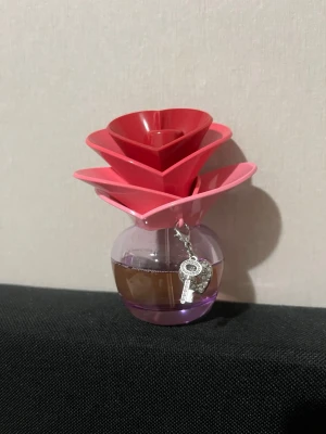 Somrig parfymflaska med rosa blomlock Justin Bieber  - Justin Bieber someday parfym en rund glasflaska med ett stort rosa blomformat lock i plast. Flaskan har en liten silverfärgad kedja med berlock. Perfekt för dig som gillar snygg design och vill ha en unik parfymflaska på hyllan.