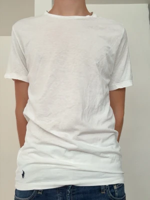 Ralph Lauren T-shirt  - Ralph Lauren T-shirt i färgen vit. Tröjan är i storlek S och i skicket 7/10. Modellen på bilden är 181cm och väger runt 60kg. Hör av dig om du har några funderingar🙌
