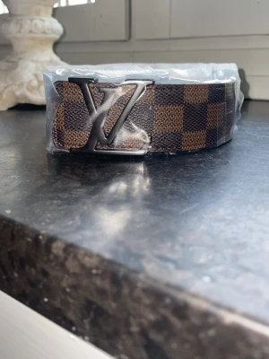 Märkes bälte - Säljer nu ett snyggt brunt bälte med svart logga! Det är helt nytt och box ingår. Har ett till likadant bälte därför det är två annonser. För fler bilder eller frågor är det bara att skriva!
