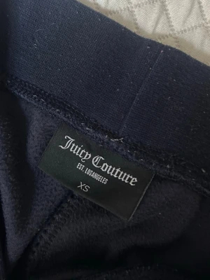 Mörkblå mjukisbyxor Juicy Couture  - Mörkblå mjukisbyxor från Juicy Couture. Tyvärr saknas smöret som ska gå runt.