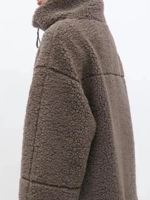 Teddy jacka gina  - Mysig brun teddyjacka med hög krage och hel dragkedja framtill. Jackan har en oversized passform, markerade sömmar och är gjord i fluffigt teddy-material som håller dig varm. Perfekt för kalla dagar och ger en trendig look.