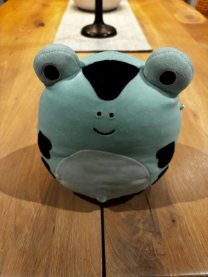 Gulligt grod-gosedjur i mintgrönt - Supermjuk och rund groda i mintgrönt plyschmaterial med stora ögon och svarta fläckar. Perfekt som kramkompis eller dekoration i rummet. Den har ett vitt ansikte och mage samt ett glatt leende.