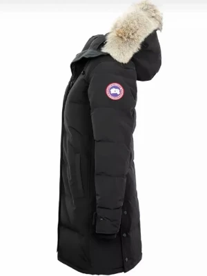 Canada goose - Snygg svart canada goose dunjacka med lång passform och huva med fluffig pälskant. Jackan har ett emblem på ärmen och praktiska fickor framtill. Perfekt för kalla vinterdagar.