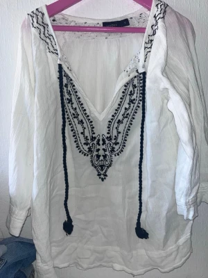 Vit boho-blus med brodyr från Indiska - Vit bohemisk blus från Indiska med svart broderi längs v-ringningen och axlarna. Från Lindex Storlek S🙌🏻🩷