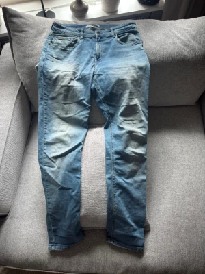 Ljusblå jeans från Calvin Klein - Snygga ljusblå jeans från Calvin Klein med klassisk femficksdesign och diskret CK-detalj på myntfickan. Jeansen har en slim fit passform och slitna detaljer framtill för en trendig look. Perfekta till vardagsoutfiten! Står storlek 16 skulle säga att de passar S