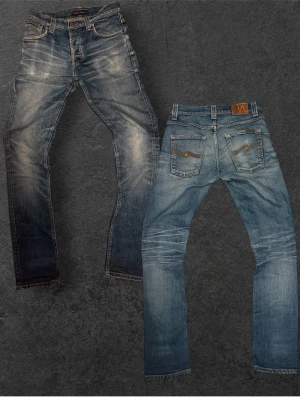 Sjukt feta vintage Nudie Jeans - Säljer ett par blå jeans från Nudie Jeans med snyggt slitna detaljer och kontrastsömmar. Jeansen har klassisk femficksmodell, raka ben och tydliga whiskers vid knä och lår. Tillverkade i bomull med en cool vintagekänsla.