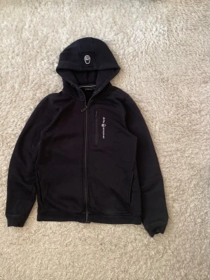Sail Racing Mörkblå/Svart Zip Hoodie (Stl 170 / XS-S) - Stilren huvtröja med hel dragkedja från Sail Racing. Tillverkad i kraftig och skön kvalitet med bröstficka, luva och broderad Sail Racing-logotyp. 170 cm (Passar även bra som Herr XS/S eller Dam S)  📦 Skickas snabbt! ✅ Svarar snabbt!