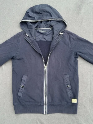 Cardigan med luva - Riktigt snygg mörkblå cardigan med fina detaljer från Marc O’Polo. Storlek M men sitter som S, fint skick. Färgen är som på sista bilderna.