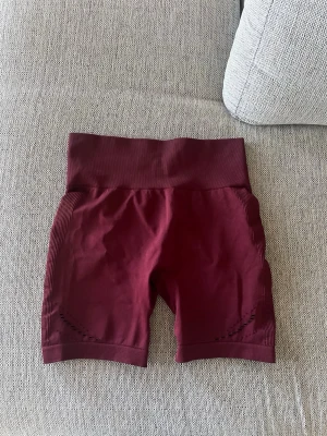 Vinröda träningsshorts - Säljer ett par vinröda seamless träningsshorts från blacc i storlek M 