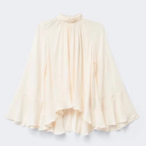 Vit volangblus med hög krage - Säljer en superfin vit blus med hög krage och volangdetaljer. Blusen har vida, långa ärmar och ett flowy, omlottliknande fall. Perfekt för dig som gillar en romantisk och elegant stil. Skriv till mig för fler bilder.