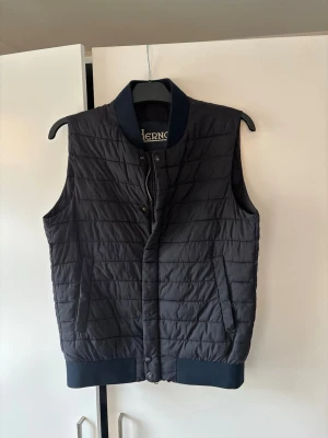 Jättefin Herno dunväst M - Jättefin eftertraktad och populär Herno dunväst i storlek M. Väldigt snygg och trendig perfekt nu till hösten och superfint skick! Inga hål eller fläckar och tveka inte vid minsta fråga eller fundering!