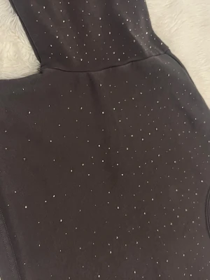 Grå sweatshirt med strassdetaljer - Trendig grå sweatshirt med små strassdetaljer över hela tröjan. Mjuk bomullskänsla och rund halsringning. Långärmad modell som ger en cool och glittrig look till din outfit.