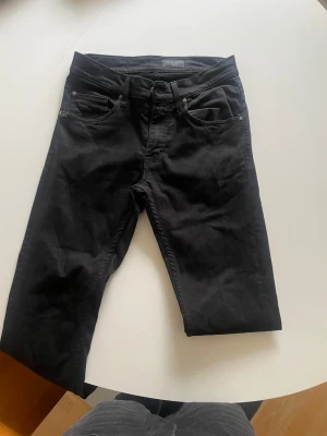 Svarta jeans från Tiger of Sweden - Snygga svarta jeans från Tiger of Sweden. De är moedelen Iggy och de är slimmade. Storleken är W28 L34