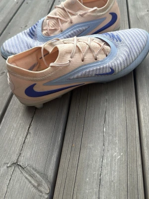 Nike fotbollsskor elite blå beige  - Säljer ett par fotbollsskor från Nike i beige och ljusblått med blått på sidan. 