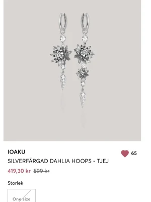 Silvriga Dahlia Hoops från IOAKU - Säljer ett par statementörhängen från IOAKU i silverfärg med blommiga dahlia-detaljer och gnistrande stenar.  Har bara använt dessa en gång så i riktigt bra skick, även slut på hemsidan!