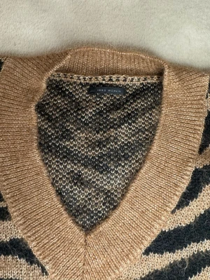 Brun stickad tröja i zebra mönster  - Säljer en skitsnygg stickad tröja med zebramönster i brunt och svart. Den sitter fint på och är perfekt nu inför hösten! Mått kan skickas privat💕ORGINALPRIS: 2200kr