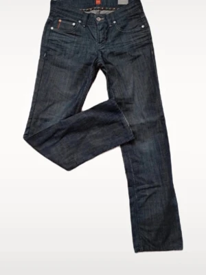 Mörkblå raka jeans herr - Snygga mörkblå jeans med raka ben och klassisk femficksdesign. Jeansen har kontrastsömmar och detaljer i silverfärgad metall. Perfekta för en avslappnad och stilren look. Materialet är denim i bomull. Kolla måtten 