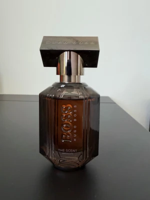 Hugo Boss The Scent Absolute parfym - Hugo Boss The Scent Absolute For Her (Eau de Parfum, 30 ml) är en otroligt lyxig, djup och sensuell doft. Den öppnar med söt och krämig honungspersika, har ett hjärta av rostat kaffe och landar i en varm bas av vanilj och vetiver. Flaskan är på 30 ml och endast några enstaka spray har använts.