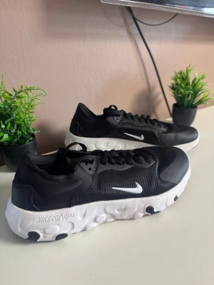 Nike React Element 55 svarta sneakers - Snygga svarta Nike React Element 55 sneakers med vit, chunky sula och små svarta detaljer undertill. Skorna har en låg profil, klassisk Nike Swoosh på sidan och ovandel i mesh och syntetmaterial. Perfekta för dig som gillar sportig och modern stil. ⚠️Storlek 44!⚠️