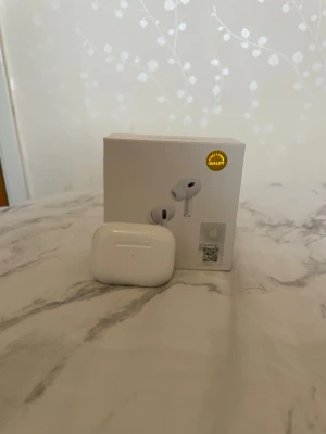 Vita trådlösa in-ear hörlurar - Säljer ett par vita trådlösa in-ear hörlurar med laddningsetui. Hörlurarna har en stilren och kompakt design med silikonproppar för bra passform. Perfekta för musik, poddar och samtal på språng. Laddningsetui med LED-indikator ingår. Airpodsen är inte original och den vänstra AirPoden funkar tyvärr inte och bara använt i fem minuter 