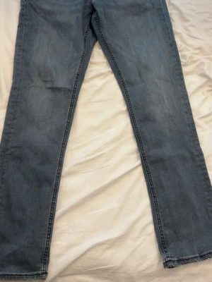 Grå jack& jones jeans - Säljer ett par klassiska blå jeans med rak passform och normal midja. Jeansen har fem fickor och är tillverkade i mjukt denimtyg. Perfekta till en avslappnad stil och passar till det mesta i garderoben.