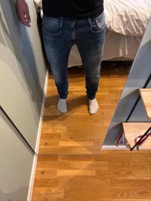 Blå slim fit jeans med tvättade detaljer - Säljer ett par blå slim fit jeans med snygga tvättade detaljer och klassisk femficksmodell. Jeansen har normal midja och smal passform hela vägen ner. Perfekta för dig som gillar en modern och avslappnad stil. Modellen är 177.