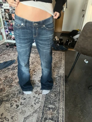bootcut jeans - Säljer ett par mörkblå bootcut jeans från bershka. Slitna längst nere. Kommer inte tvätta innan.