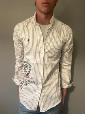Vit randig skjorta från Polo Ralph Lauren - Riktigt unik ralph lauren skjorta. Perfekt för en lite niche stil och passar till allt och gör hela outfiten😍💯