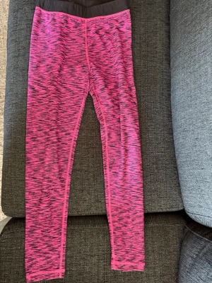 Rosa och svarta mönstrade leggings - Säljer ett par snygga leggings i rosa och svart mönster med bred svart midjeresår. Stretchigt material som sitter tajt och bekvämt. Perfekta för träning eller chill. Inga fickor eller dragkedjor, bara enkel och stilren design. Vet inte storleken men kan mäta midjan!!! Skriv privat för fler bilder eller om du har några frågor💗