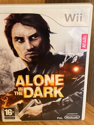 Alone in the Dark till Nintendo Wii - Alone in the Dark är ett actionäventyrsspel till Nintendo Wii där du utforskar ett mörkt och mystiskt New York. Omslaget är svart, vitt och orange med en dramatisk illustration. Spelet har stöd för Wii Remote och Nunchuk och är rekommenderat för spelare över 16 år. Perfekt Skick