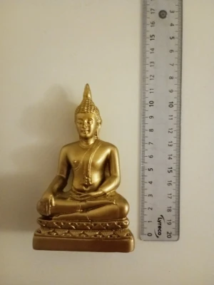 Guldfärgad Buddha-statyett - En dekorativ Buddha-statyett i guldfärg, tillverkad i metall eller liknande material. Figuren sitter i meditationsställning på en detaljerad bas. Perfekt som inredningsdetalj eller för dig som gillar österländsk estetik.